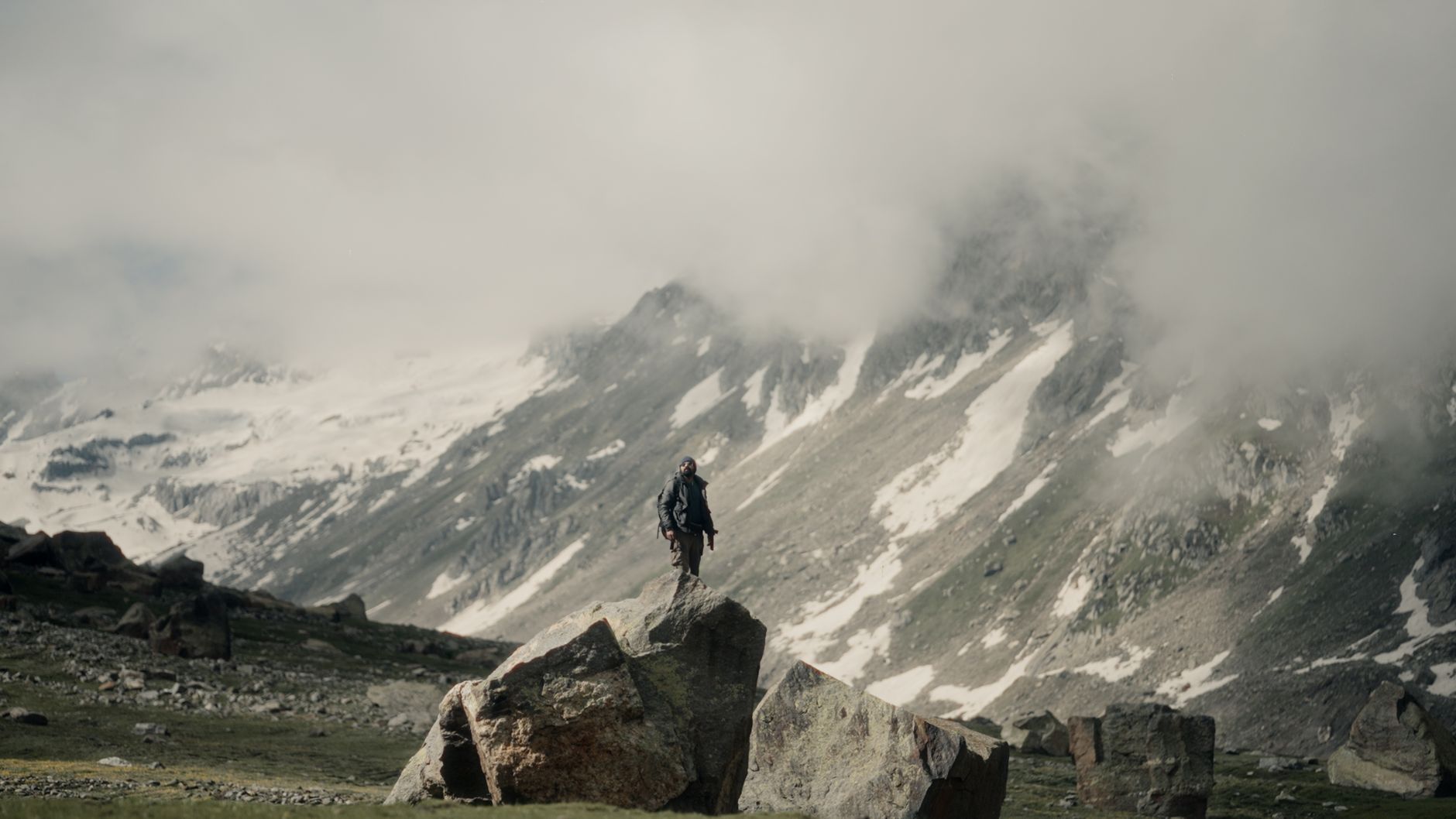 adventurer standing on mountain rock in misty landscape